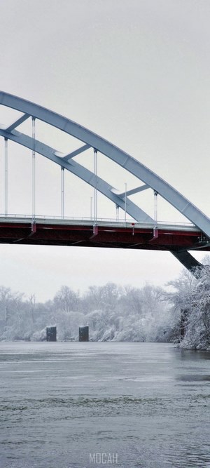 Arch bridge over a frozen river in winter