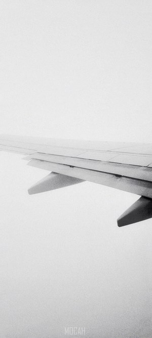 Airplane wing flying above clouds