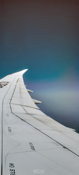 Airplane wing in the sky with rainbow effect