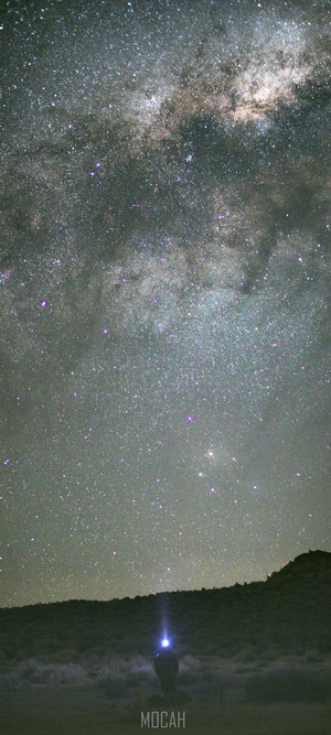 Person with headlamp under the Milky Way
