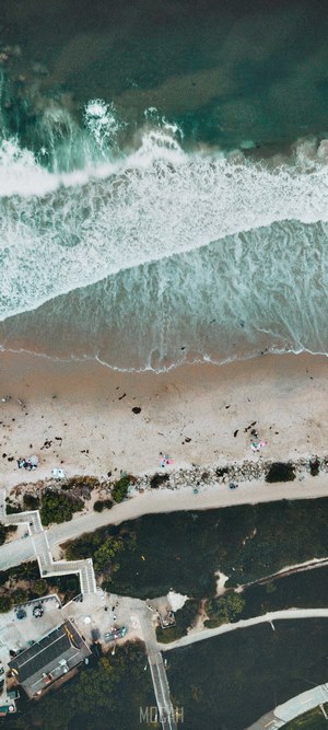 Aerial view of a beach with waves and people