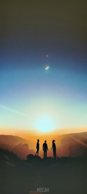 Three people silhouetted against a sunset in Yosemite