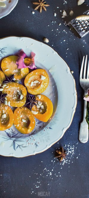 Halved apricots with spices and nuts on a plate