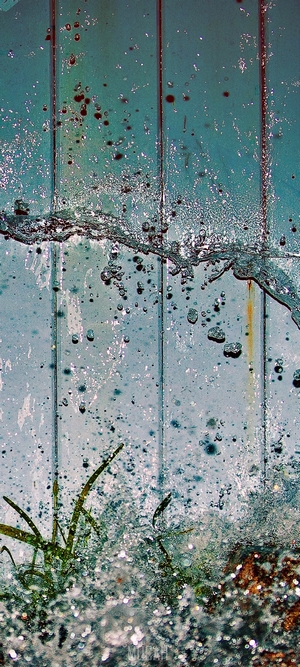 Water splashing on a blue and green surface with grass