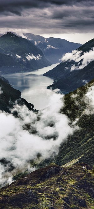 Misty mountains and a fjord under a cloudy sky