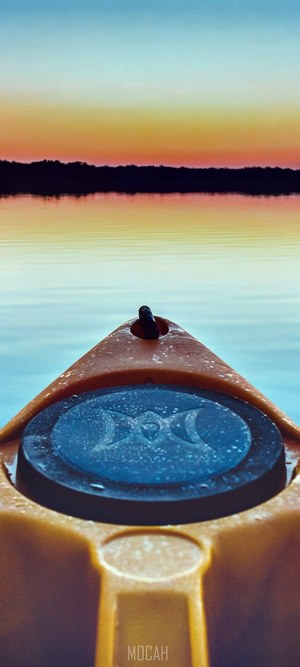 Kayak on calm water at sunset