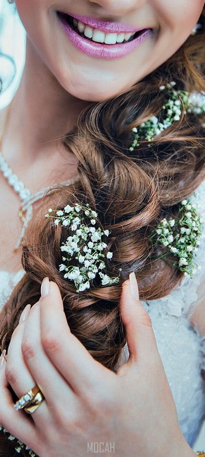 Bride with flowers in braided hair and diamond necklace