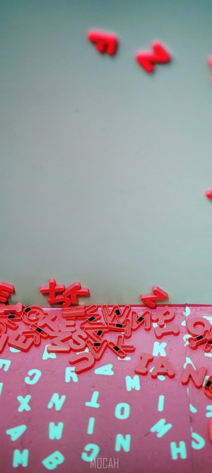 Red alphabet letters scattered on a pink surface