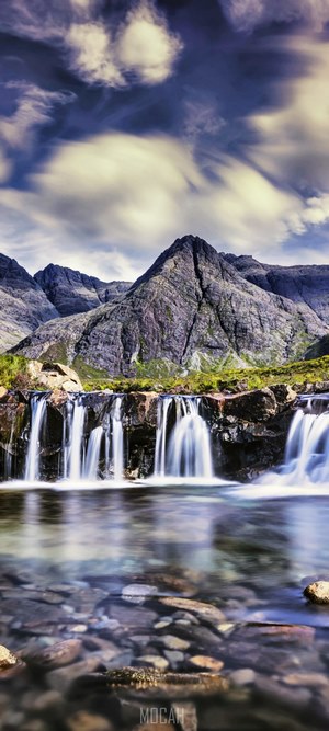 Mountain waterfall with dramatic clouds