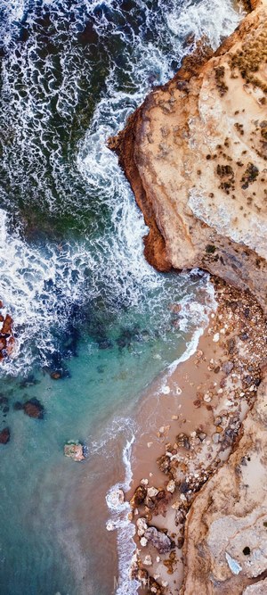 Aerial view of a rocky coastline with waves crashing