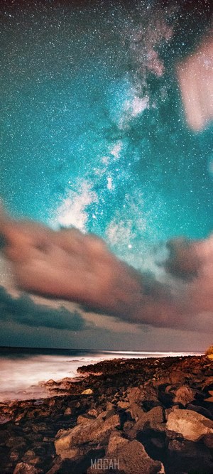 Milky Way over rocky shore and clouds