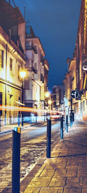 Street at night with light trails and historic architecture