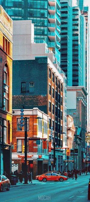 City street with modern and old buildings, orange taxi