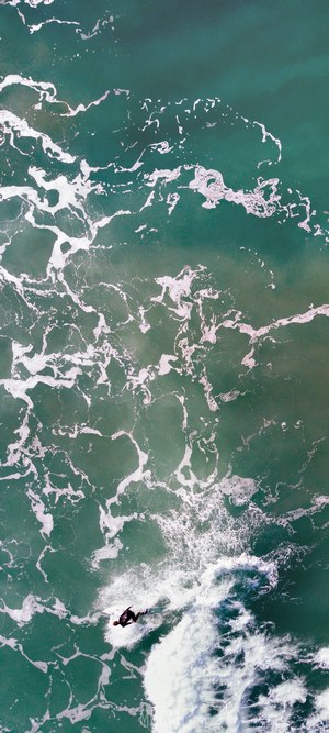 Surfer riding a wave in Gisborne, New Zealand