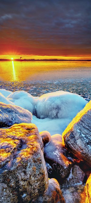 Sunset Over Icy Rocky Shoreline