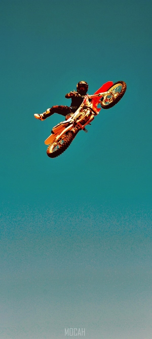 Motocross rider performing a stunt against a blue sky
