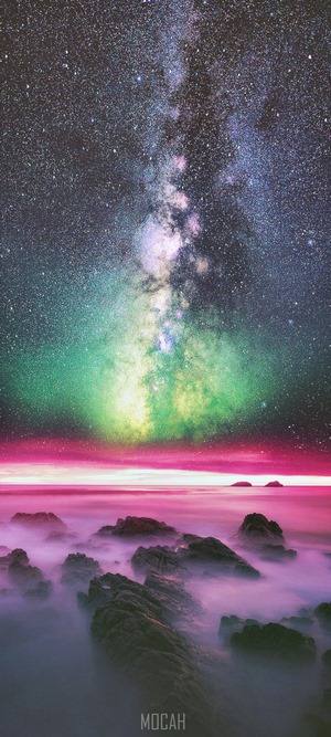 Milky Way over rocky coast with aurora