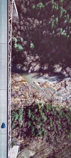 Drone shot of a car on a bridge over a ravine