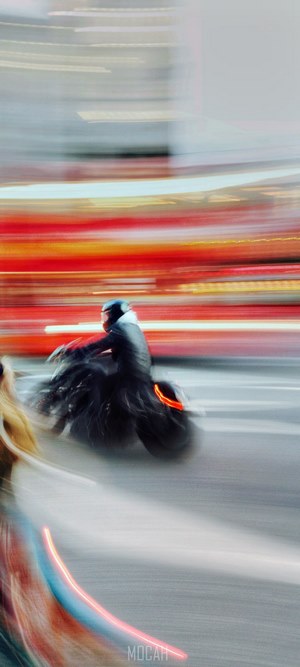 Motorcyclist on a busy street with light trails