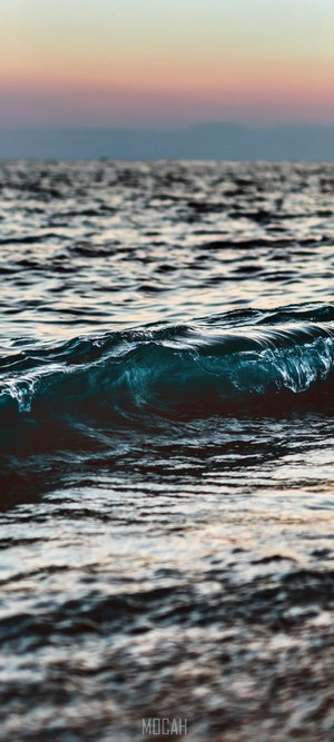 Wave crashing in the ocean at sunset