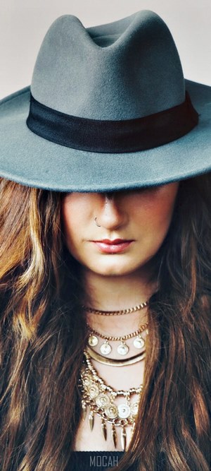 Woman wearing a hat and necklaces