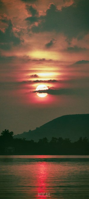 Sunset over a lake with a mountain silhouette