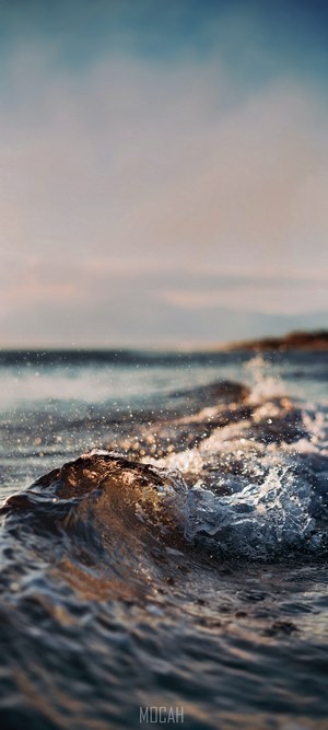 Close-up of a small wave crashing on a beach