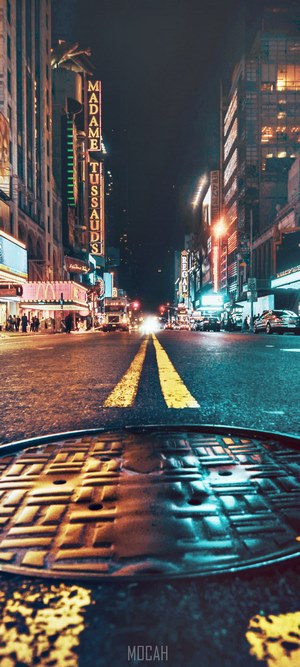Nighttime street with Madame Tussauds sign and manhole