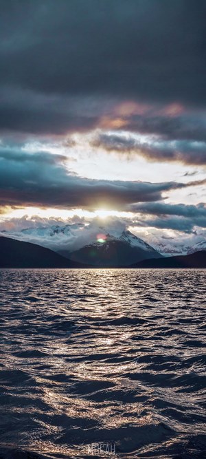 Sunset over mountains and water