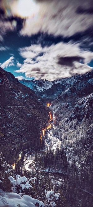 Snowy mountains with a glowing river at dusk