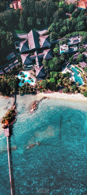 Aerial view of a tropical resort with a pier and beach