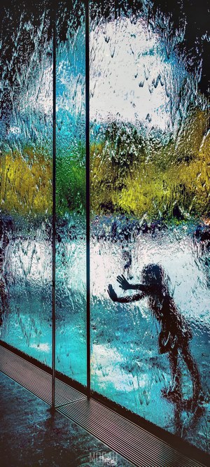 Silhouette of a child behind a waterfall