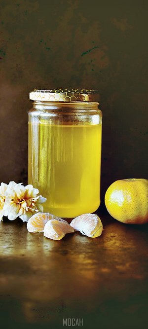 Jar of honey with clementines and flowers