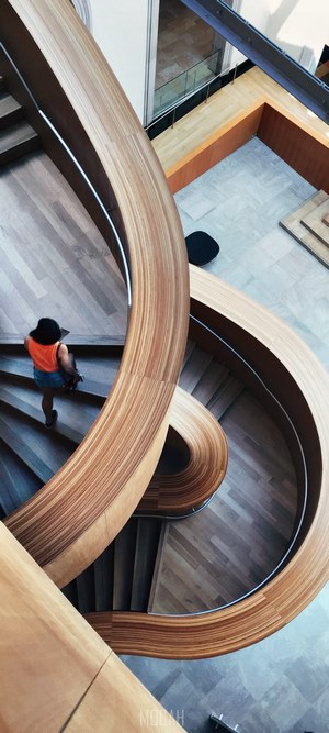 Woman on a modern wooden spiral staircase