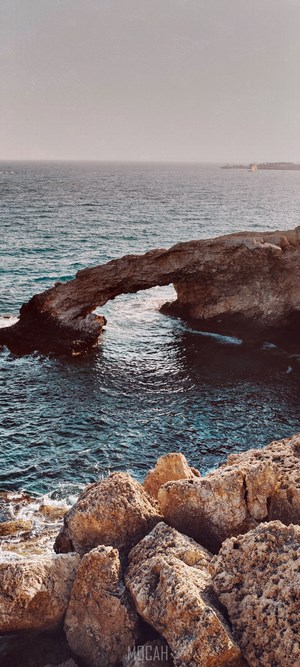 Sea Arch Rock Formation Over Blue Ocean Water