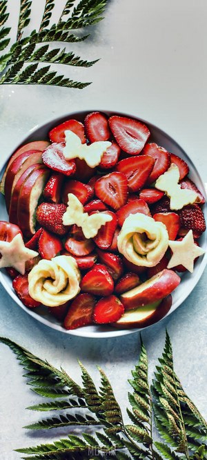 Fruit platter with strawberries, apples, and pastry decorations