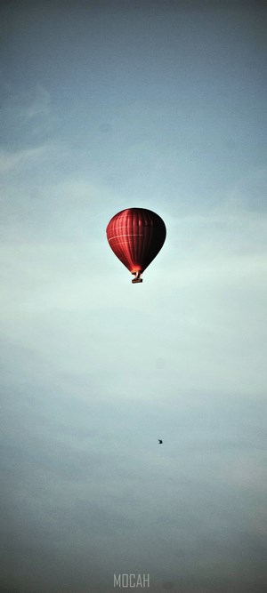 Red hot air balloon in a pale blue sky