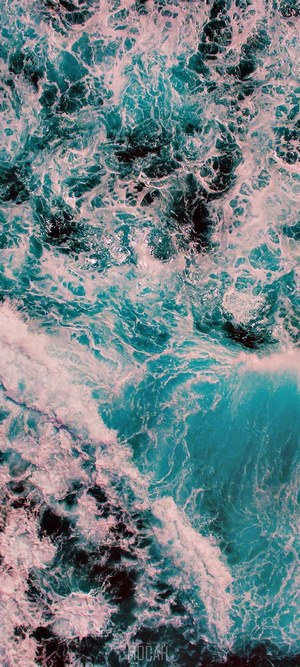 Aerial view of turquoise ocean waves crashing