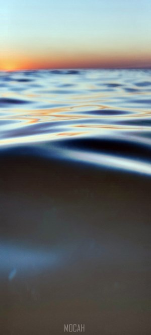 Aerial view of sea waves at sunset