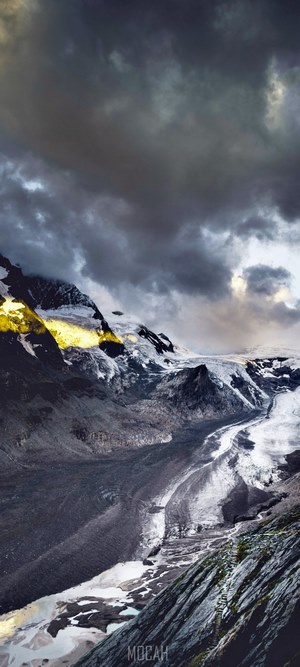 Glacier and mountains under stormy sky
