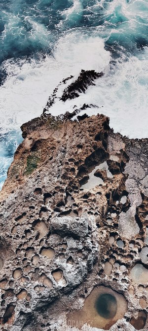 Waves crashing on rocky shore with tide pools