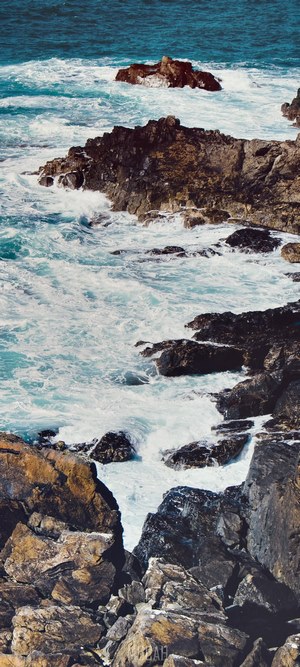 Waves crashing on rocky shore at Cape Cornwall