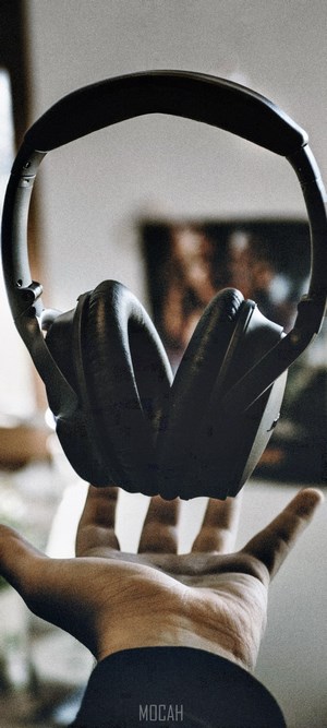 Black headphones held over a hand
