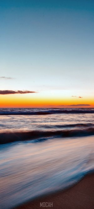 Ocean waves at sunset with golden horizon