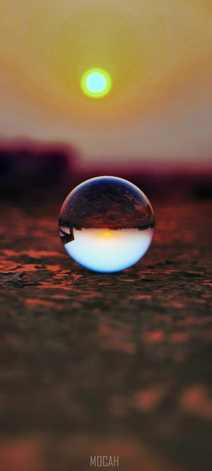 Sunset reflection in a glass ball on the ground