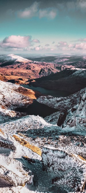 Snowy mountain range with a lake and clouds