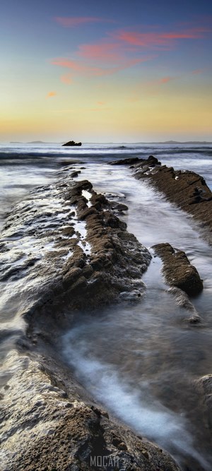 Sunset over rocky coast at Broad Haven, Wales