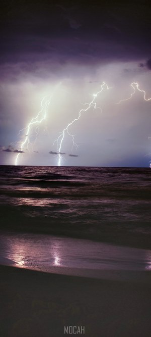 Lightning strikes over the ocean during a storm