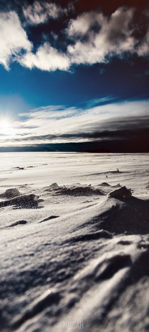 Snowy landscape under a cloudy blue sky