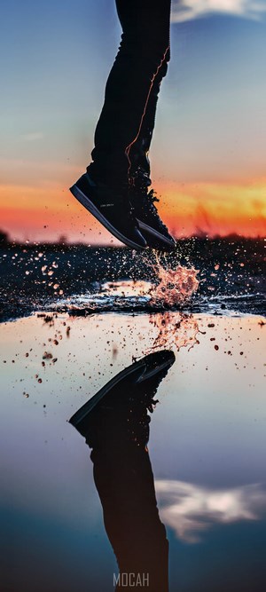 Person jumping through water with reflection